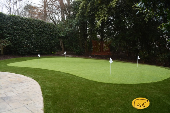 Toronto Synthetic grass golf green with 4 holes and flags in a landscaped backyard