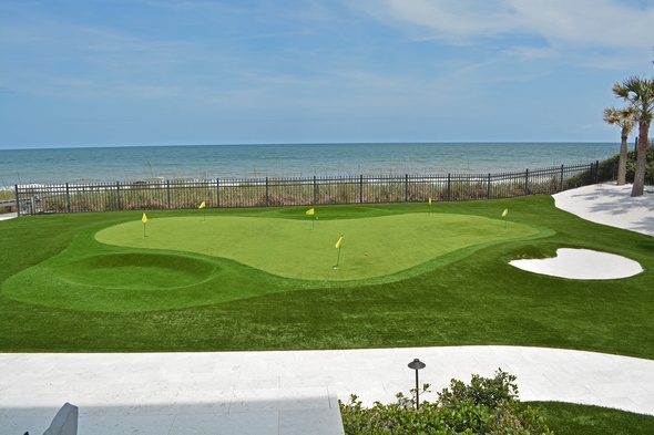 Toronto Synthetic grass golf green by the sea with yellow flags and a sand bunker