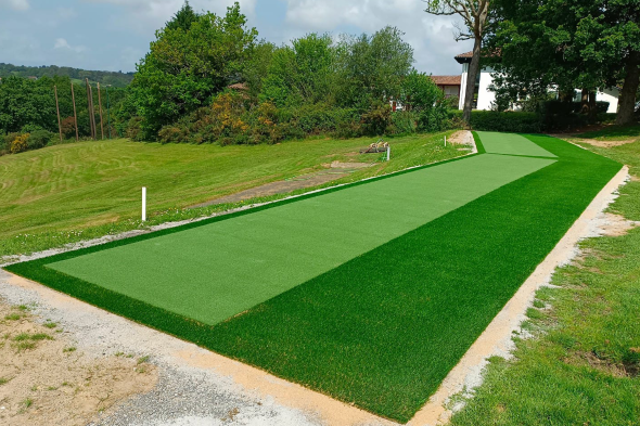 Toronto Outdoor tee line consisting of one continuous green synthetic grass strip surrounded by trees